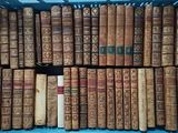 many old books in a blue crate on the floor
