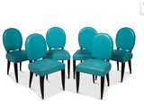 four blue leather dining chairs with black legs and a white background