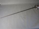 a sword that is sitting on a table next to a roll of toilet paper