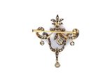 a close up of a gold and diamond broochle on a white background