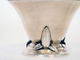 a silver vase with a flower decoration on top of it