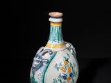 a blue and white vase sitting on a black surface
