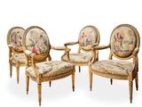 trois chaises dont le dossier est recouvert d'une tapisserie et une chaise avec un repose-pieds