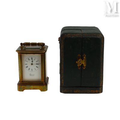 une petite horloge posée à côté d'une petite boîte noire