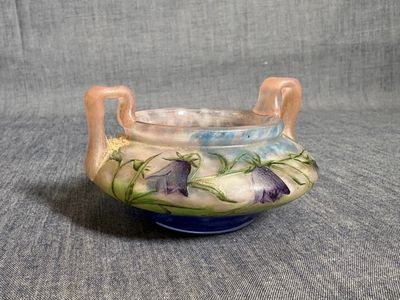 un vase bleu et blanc orné de fleurs violettes