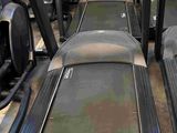 row of tread machines in a gym room with treads on the floor