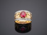 a gold ring with a ruby stone and diamonds