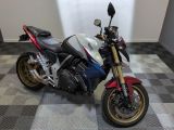 une moto rouge, blanche et bleue garée sur un sol à damier