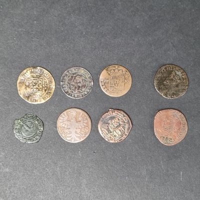 six pièces de monnaie britanniques différentes posées sur une table, sur fond noir