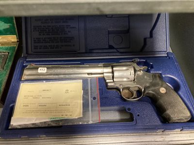 un pistolet dans un étui bleu posé sur une étagère
