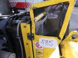 un gros plan d'un engin de chantier jaune sur lequel est apposé un panneau