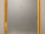 un miroir à cadre doré sur fond blanc