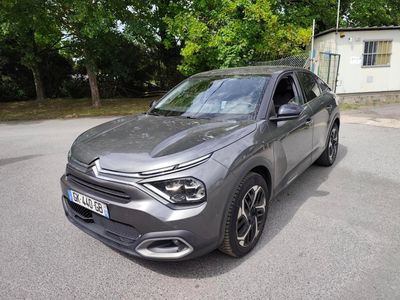 La voiture grise est garée dans la rue, devant une maison.