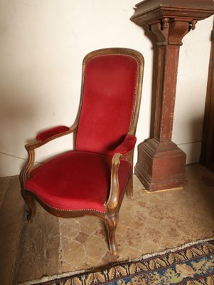 une chaise rouge placée devant une horloge
