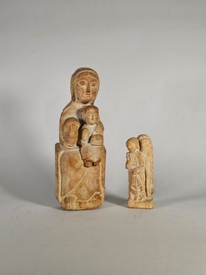 une petite statue représentant une femme tenant un enfant dans ses bras et un homme tenant un bébé