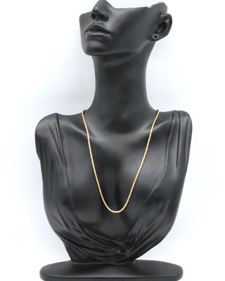 a black mannequin head with a gold chain on it