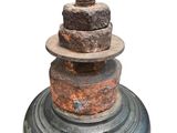 a large metal bell with a bunch of nuts on top of it