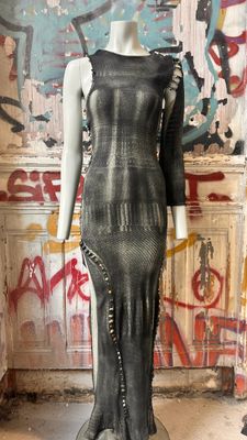 a mannequin in front of a wall with graffiti on it