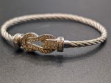 a close up of a silver bracelet with a knot on it