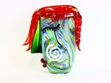 un vase en verre coloré orné d'un ruban rouge