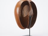 sculpture of a wooden hat on a metal stand on a white background