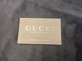a close up of a black jacket with a gold gucci logo on it