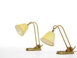 pair of brass table lamps with yellow shades on a white surface