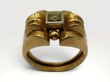 a close up of a gold ring with a square stone in the middle