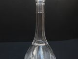 clear glass decanter on a black surface with a black background