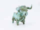 a statue of a bull that is standing on a white surface