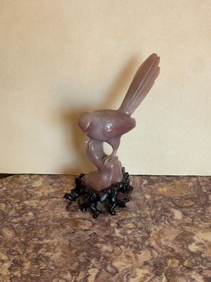 une figurine représentant un oiseau posé sur une table