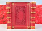un vieux livre rouge posé sur une table près d'un mur rouge