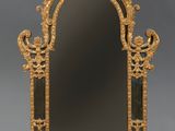 un miroir richement sculpté, avec un cadre doré sur fond gris