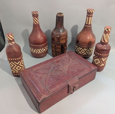 Plusieurs vases et une boîte sont posés les uns à côté des autres sur une table