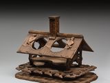 une image représentant une maquette en bois d'une maison posée sur un rocher