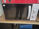 un micro-ondes posé sur une table, avec une boîte dessus