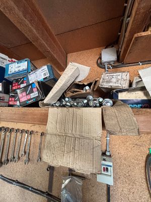 une photo d'un garage avec beaucoup d'outils sur le sol