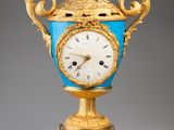 un vase doré et bleu orné d'une horloge