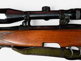 a rifle with a scope on it and a green strap