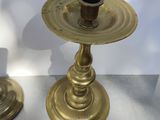 pair of antique brass candlesticks on marble table with white background