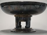 a large metal bowl with a stand on top of it