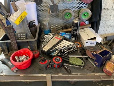 une valise remplie d'outils divers, posée sur une table