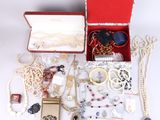 a red box filled with jewelry on a white surface