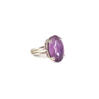 Gros plan sur une bague ornée d'une pierre violette