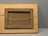 an old picture frame with a rope hanging from it ' s side