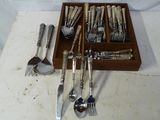 une boîte en bois contenant de l'argenterie, posée sur une table blanche
