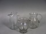 three glass pitchers and a glass jug on a table