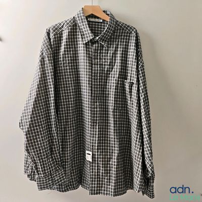 a black and white checkered shirt hanging on a hanger
