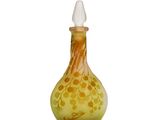 a yellow glass bottle with a white top on a white surface