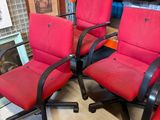 three red office chairs with black arms and arms are sitting in a room